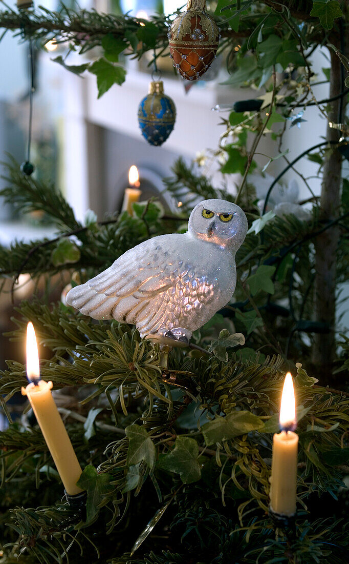 Weihnachtsbaum-Detail mit Kerzen und Eulenschmuck