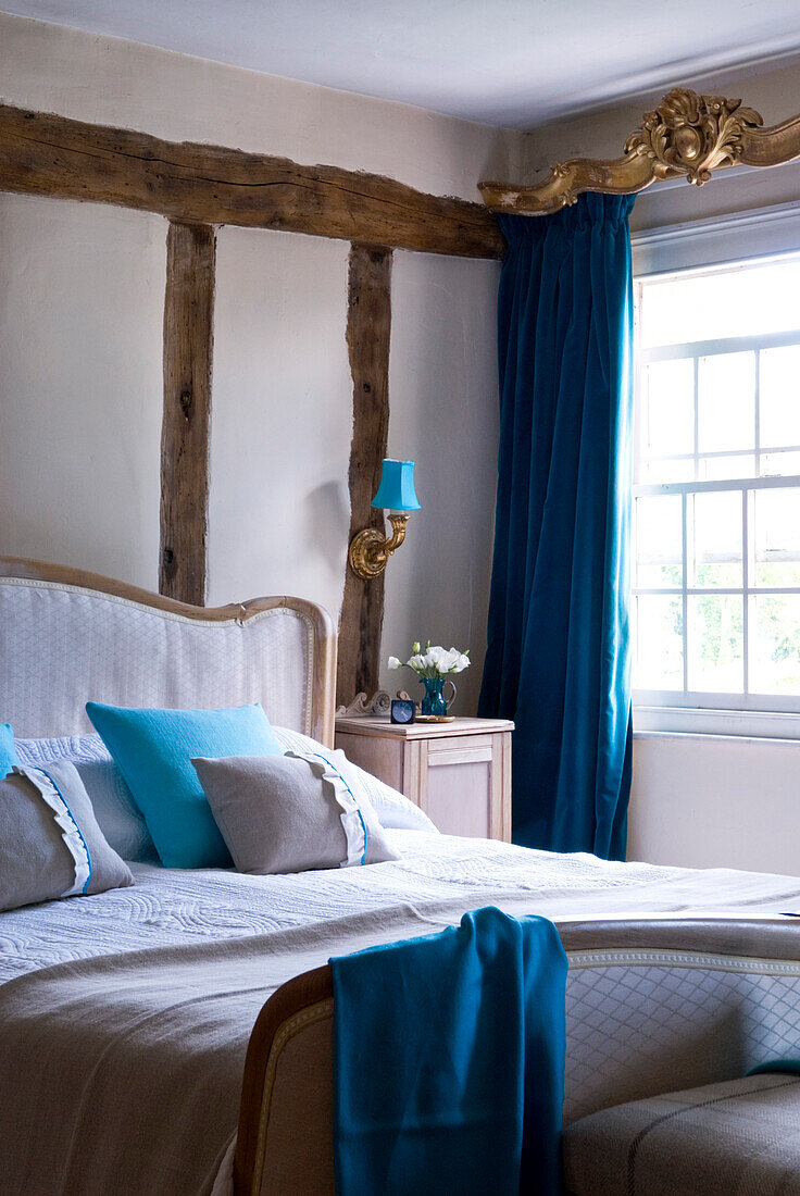 Schlafzimmer mit blauem Samtvorhang mit antiker vergoldeter Blende und Wandleuchte in blauem und weißem Dekor