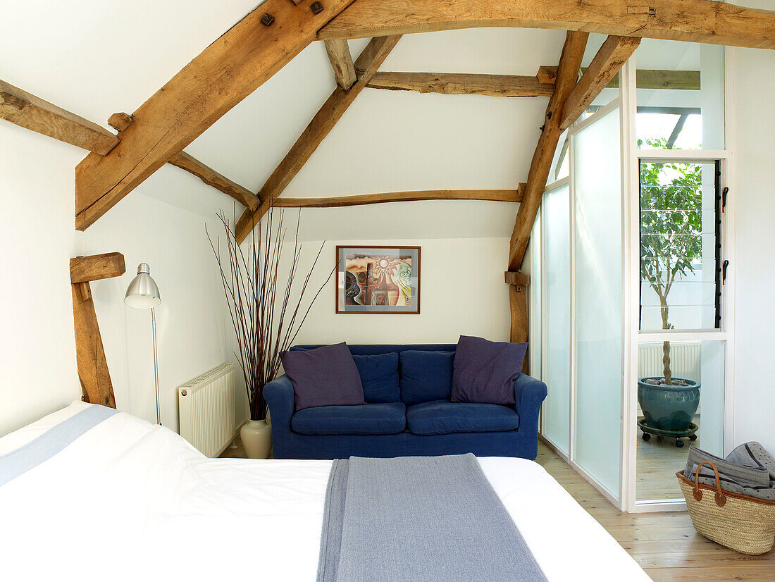 Geräumiges modernes Schlafzimmer im Dachgeschoss mit Doppelbett und Sofa