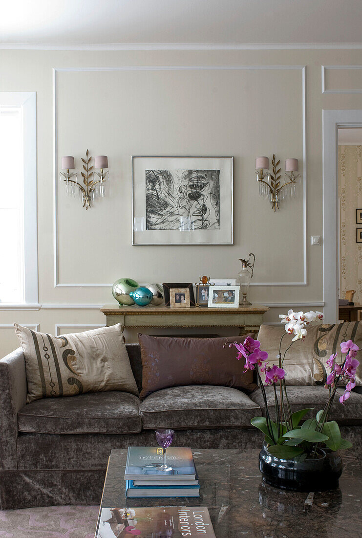 Eklektisches Wohnzimmer mit Sofa und Orchidee auf dem Tisch