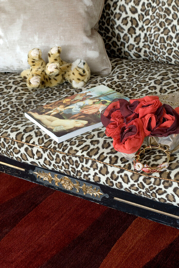 Leopard pattern sofa with small leopard toy close up