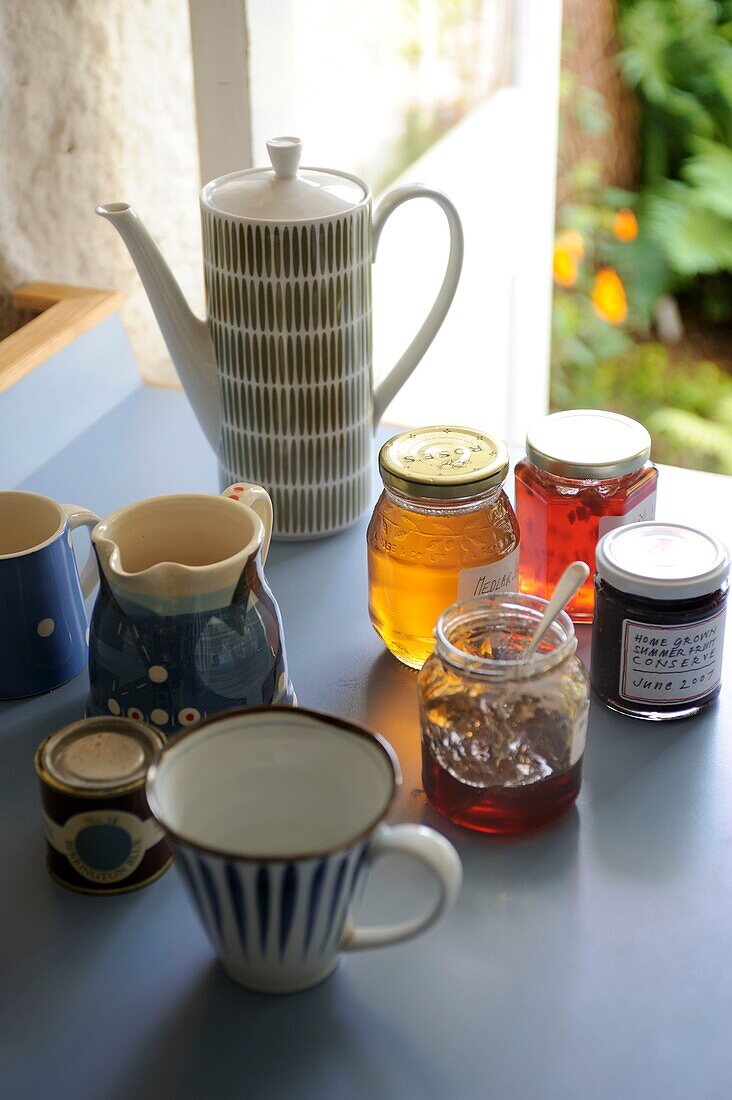 Teetasse und Marmeladengläser auf der Küchenarbeitsplatte