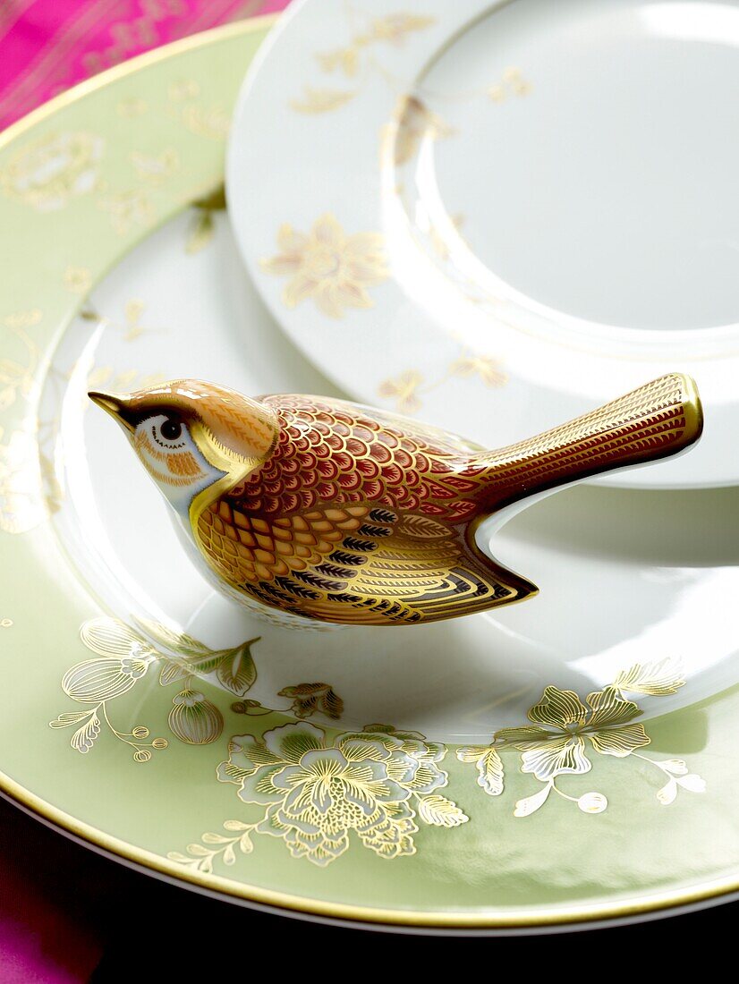 Detail eines gemusterten Geschirrs mit Keramikvogel
