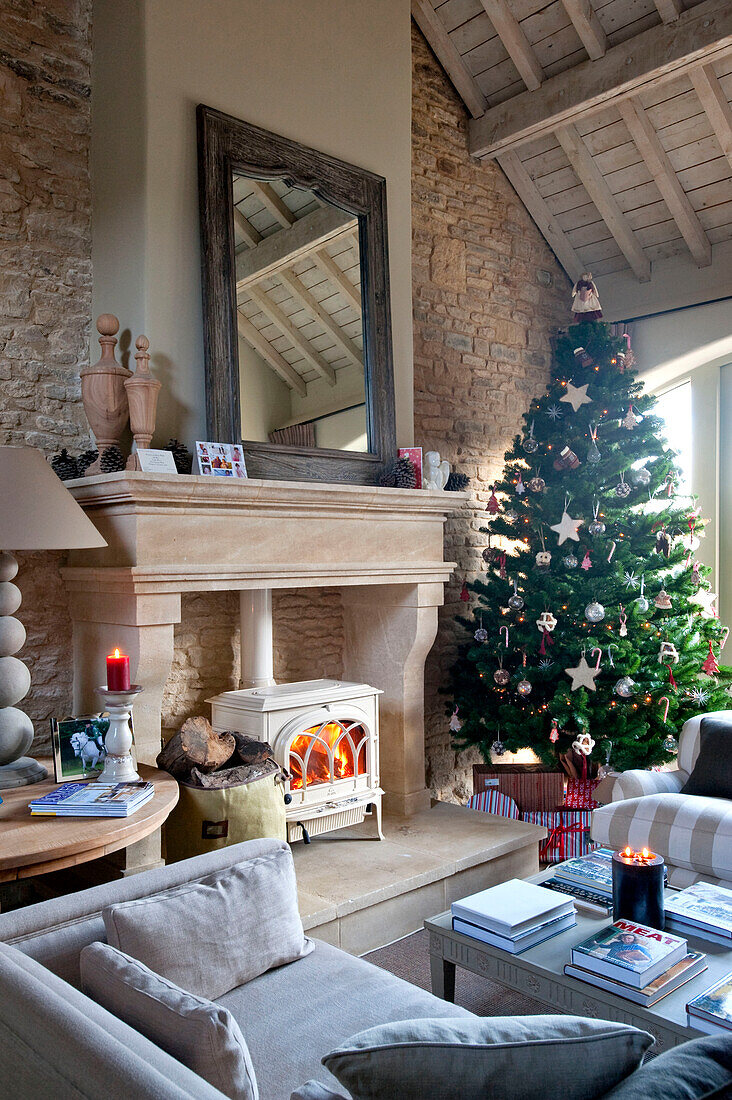 Weihnachtsbaum am Schornstein mit Holzofen in einem Bauernhaus in Wiltshire