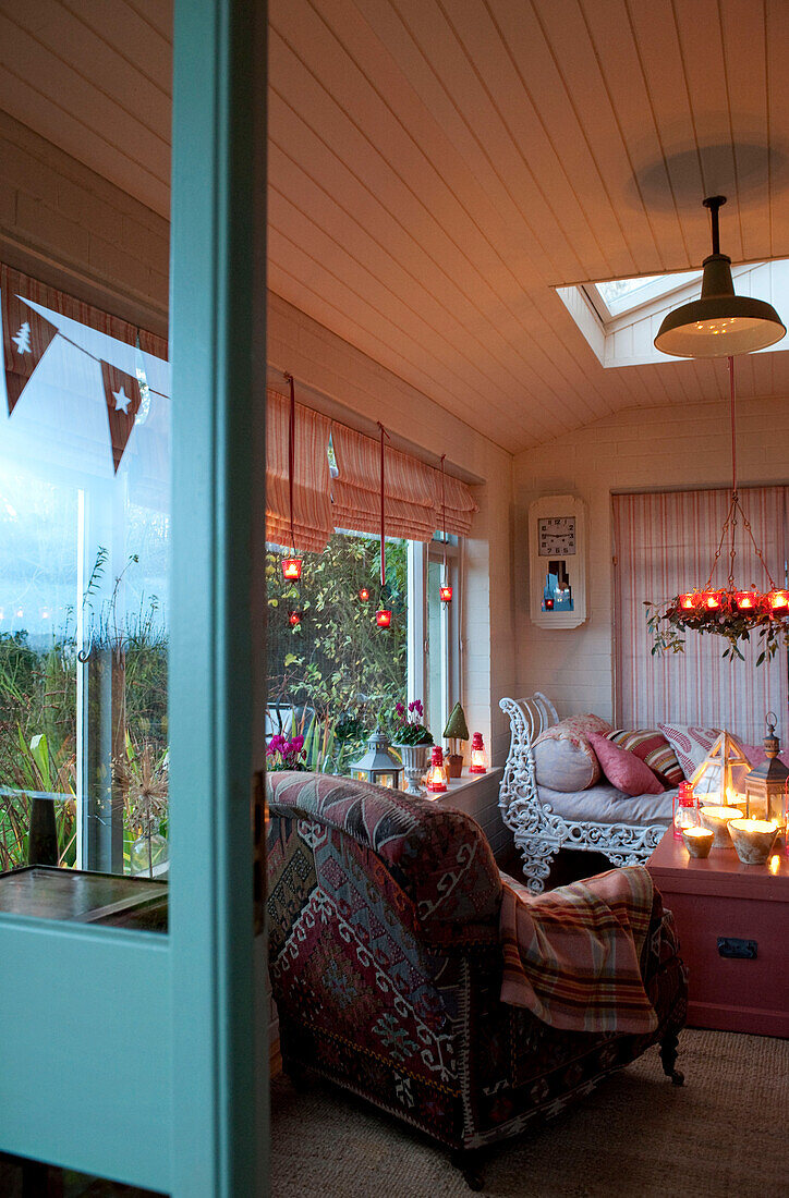 Blick durch den türkisfarbenen Türrahmen ins Wohnzimmer mit brennenden Kerzen Hereford