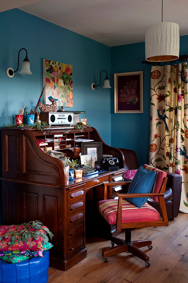 Sessel im Arbeitszimmer mit blauer Wand und geblümten Vorhängen