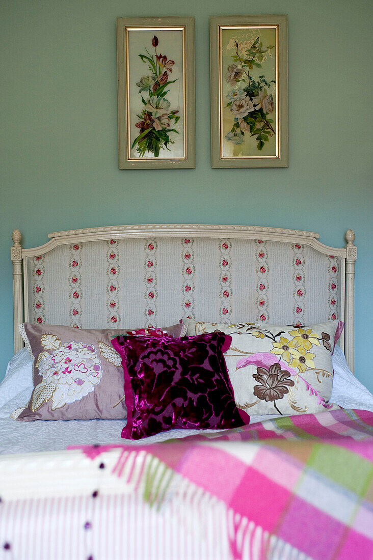 Mirrored floral artwork above headboard with cushions