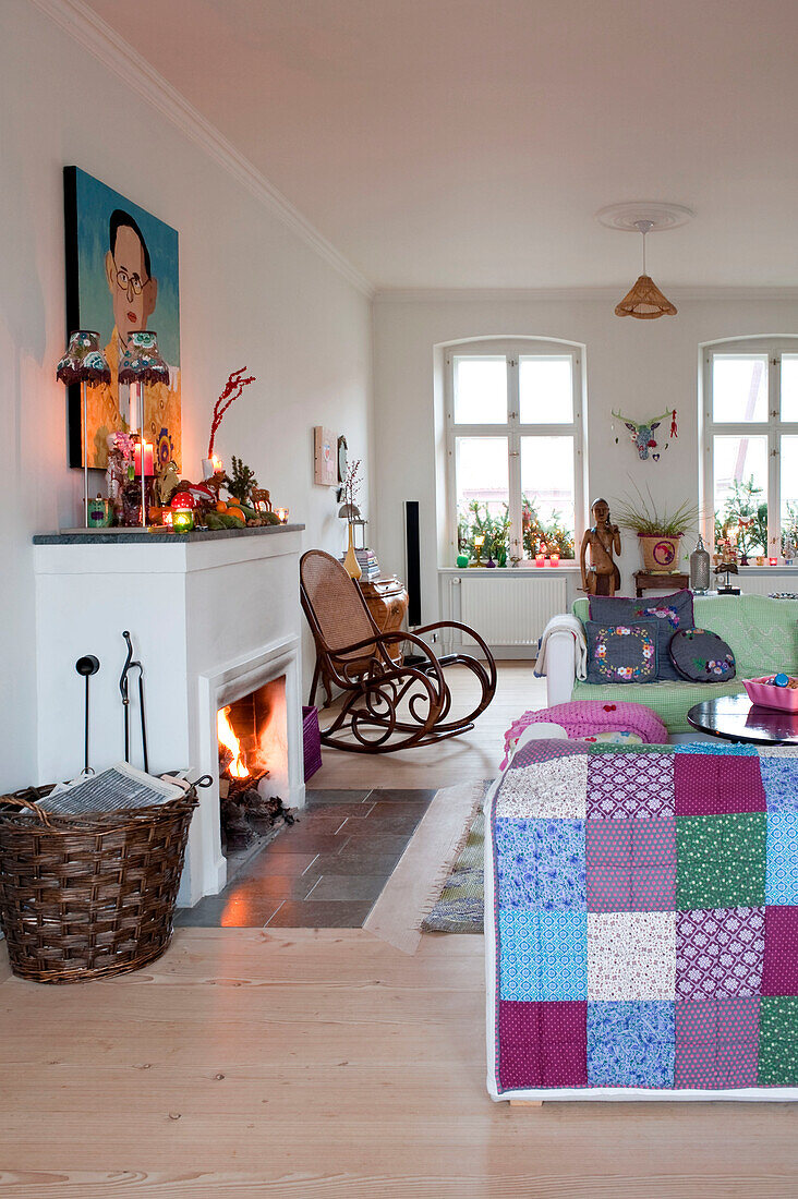 Patchworkdecke über dem Sofa am offenen Kamin mit Schaukelstuhl im Wohnzimmer in Odense