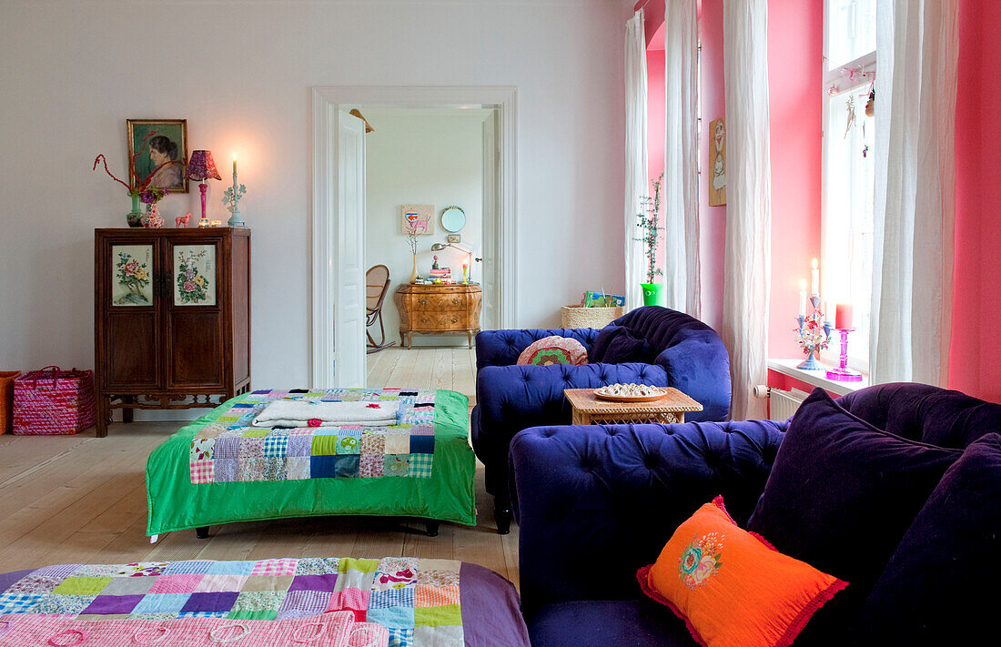 Patchwork ottoman covers in spacious Odense living room with view through doorway