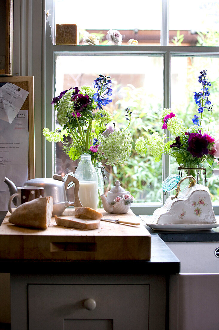 Küchenarbeitsplatte mit Schneidebrett, Küchenutensilien und Blumenständer