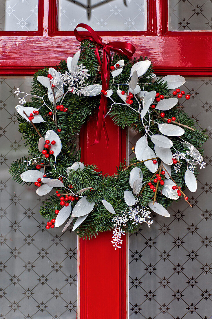 Christmas garland on red front door of London home UK