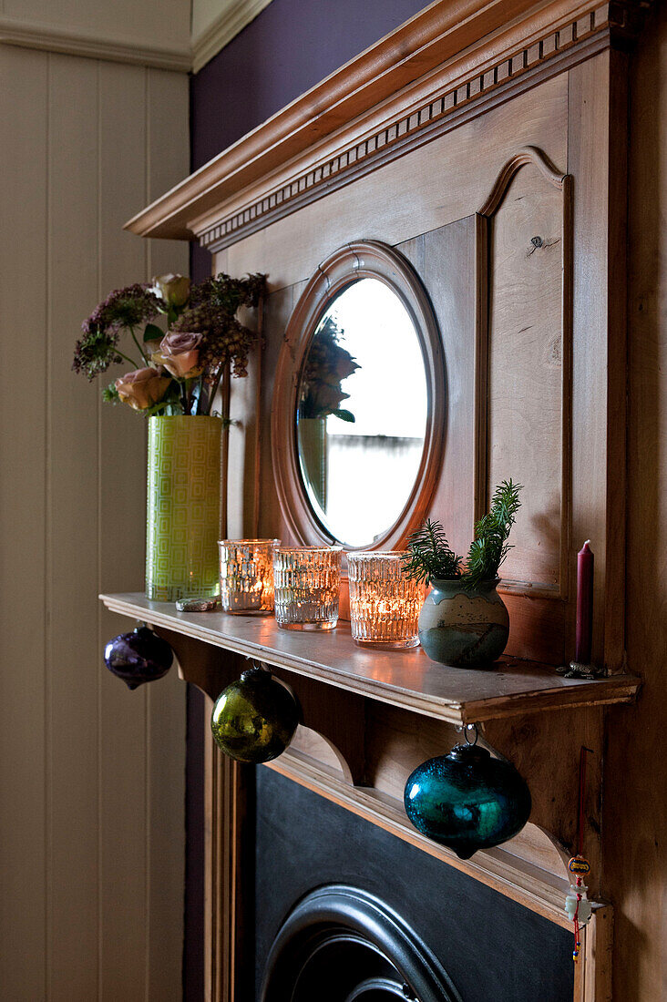 Weihnachtsdekoration und Trockenblumen auf einem geschnitzten Holzregal in einem Londoner Haus UK