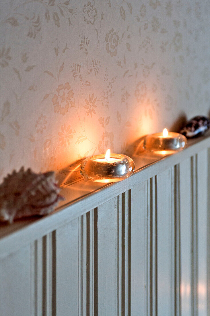 Seashells and lit candles on dado shelf in London home UK