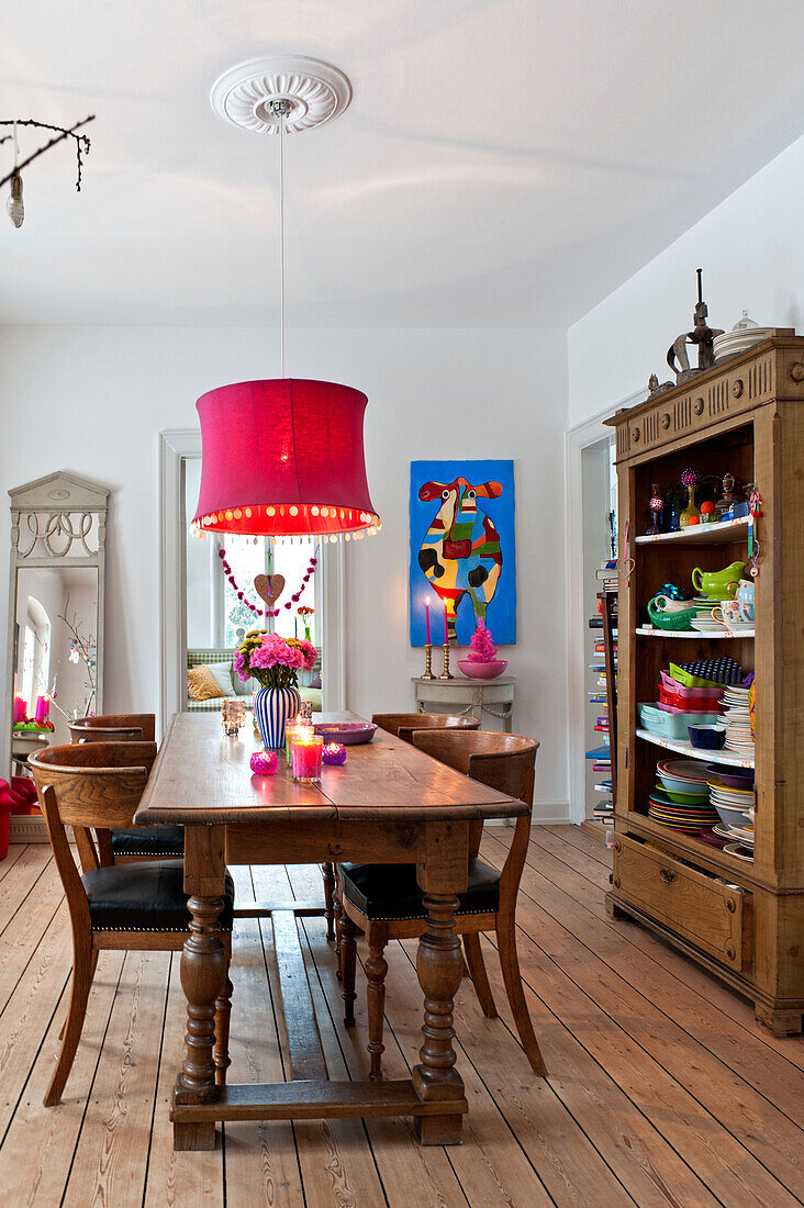 Rosa Deckenlampe hängt über einem hölzernen Esstisch in einem modernen Einfamilienhaus in Odense, Dänemark