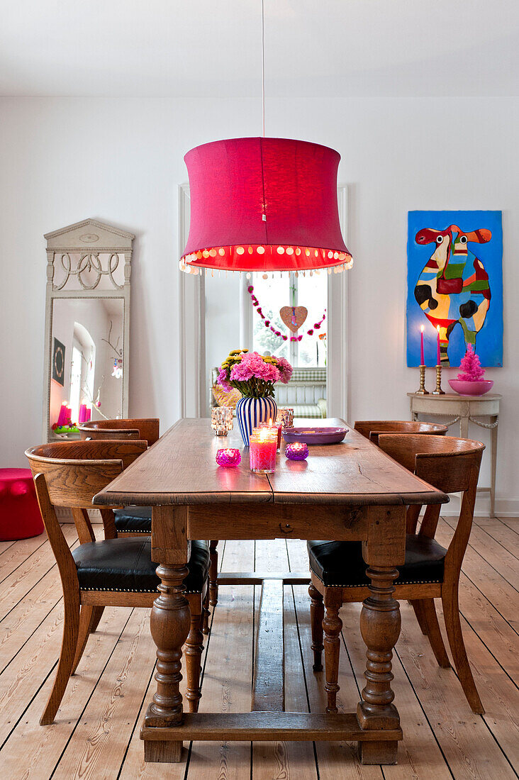 Pinke Deckenleuchte hängt über einem hölzernen Esstisch in einem modernen Einfamilienhaus in Odense, Dänemark