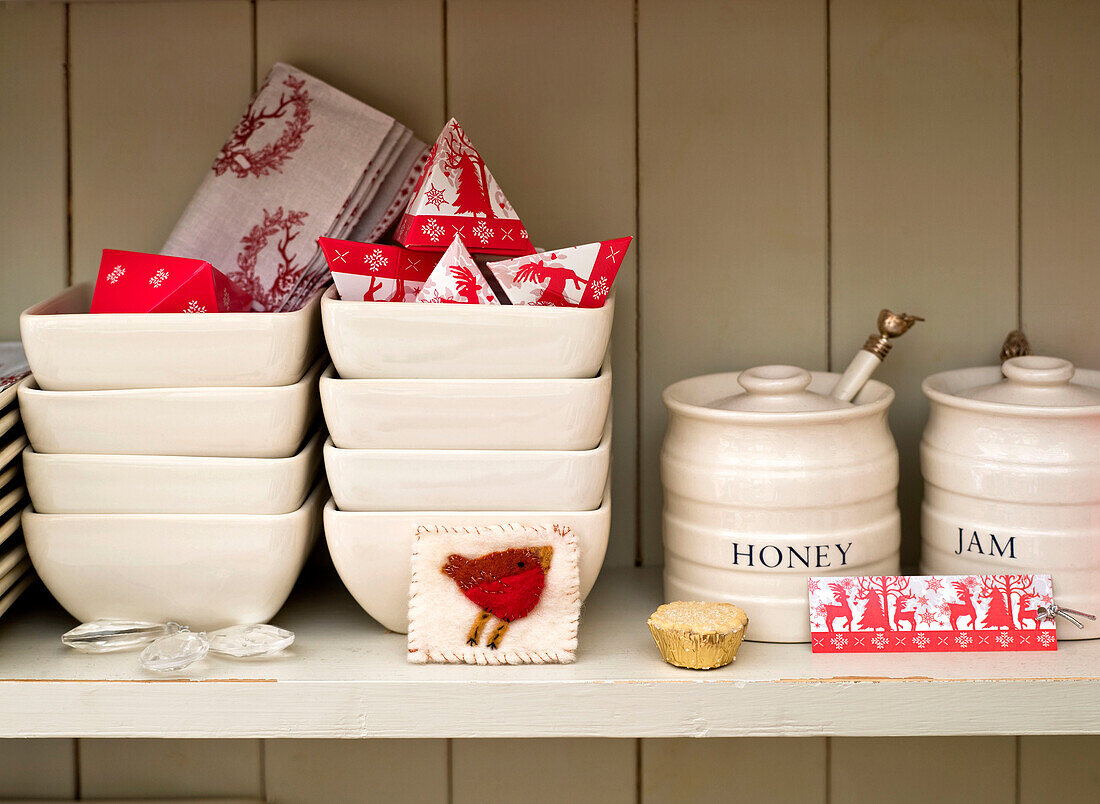 Honig- und Marmeladengläser auf einem Regal mit Keramikschalen und Weihnachtskarten in einem Londoner Haus