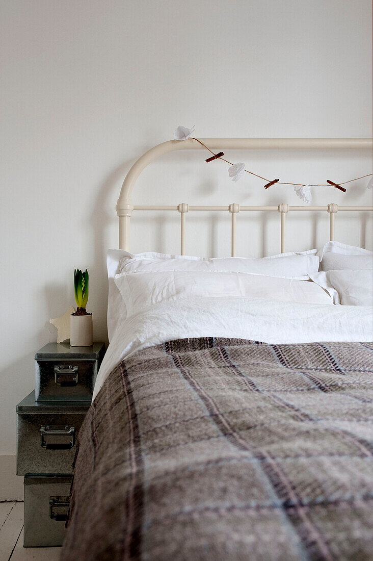 Woolen blanket on metal framed bed in Richmond home