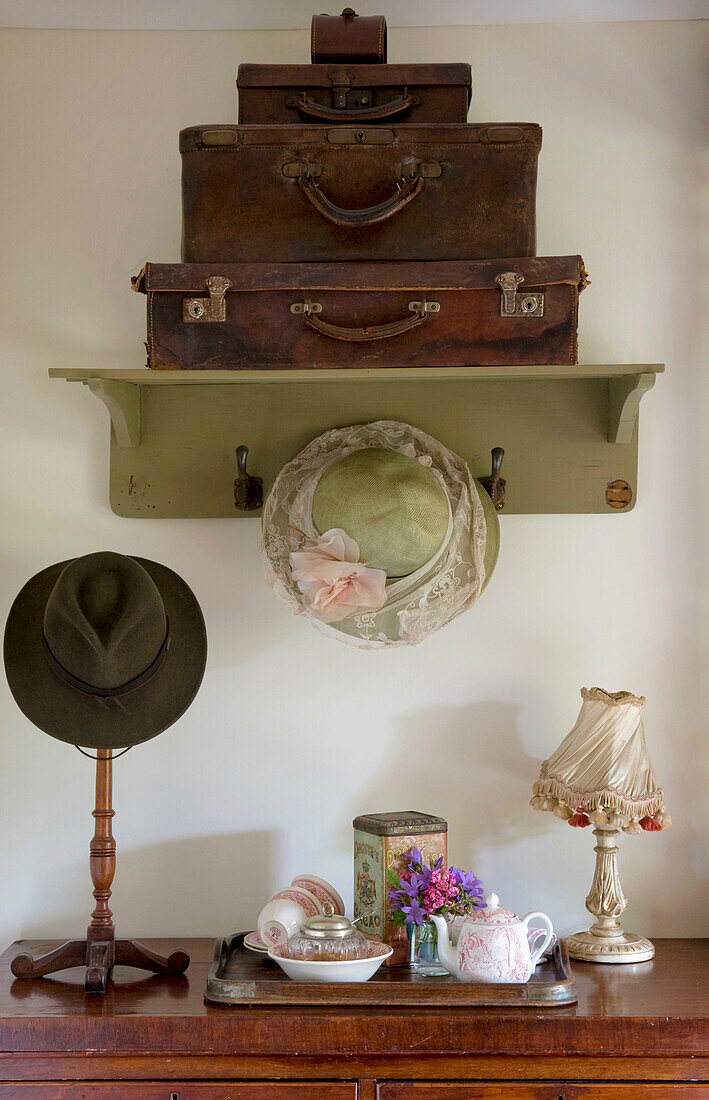 Braune Koffer und alte Hüte mit Teetablett in einem Haus in Devon