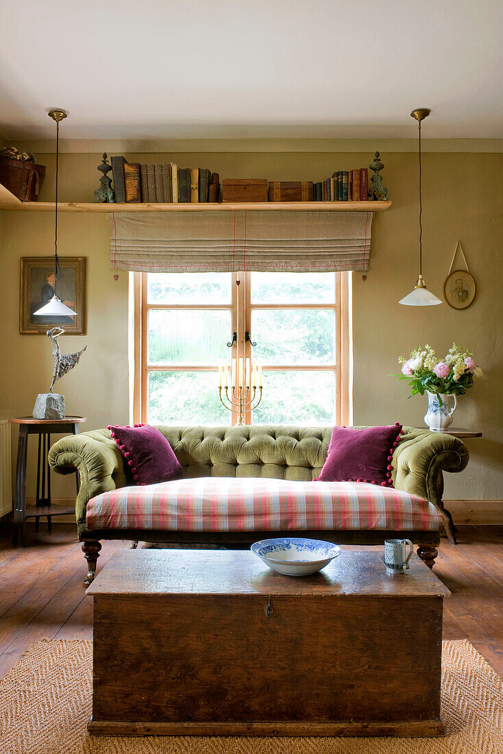 Shelf above window of Devon home with Chesterfield and wooden storage box