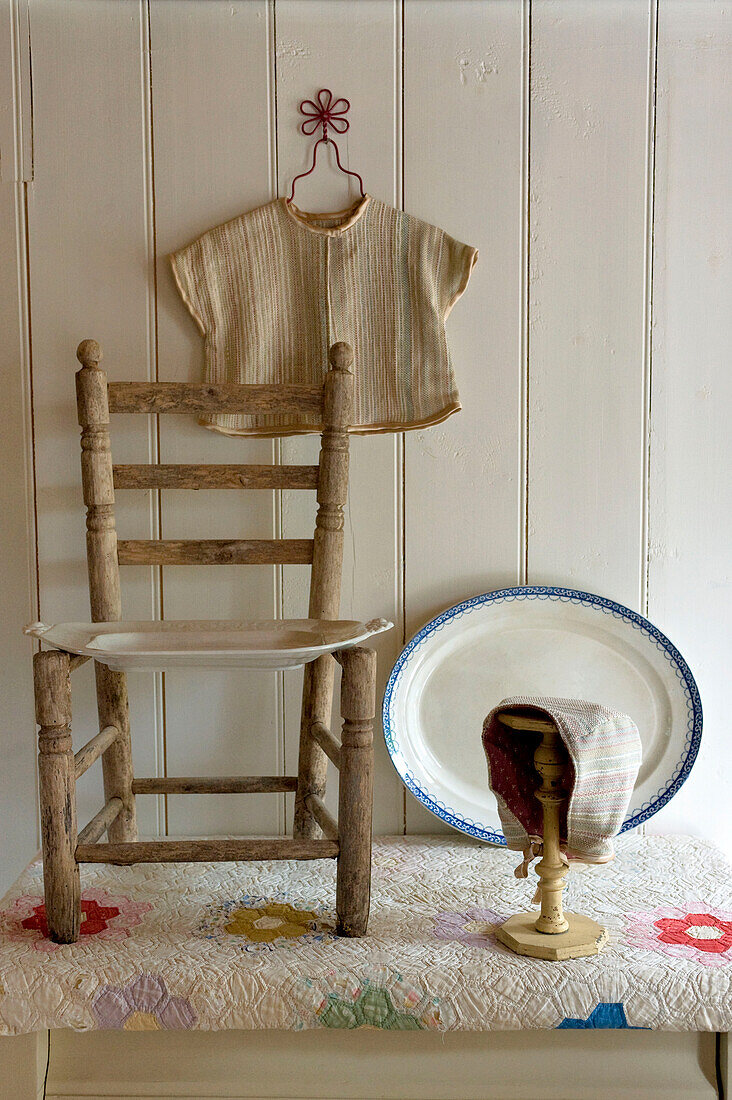 Holzstuhl und Servierplatten mit Kleidung und Haube Devon