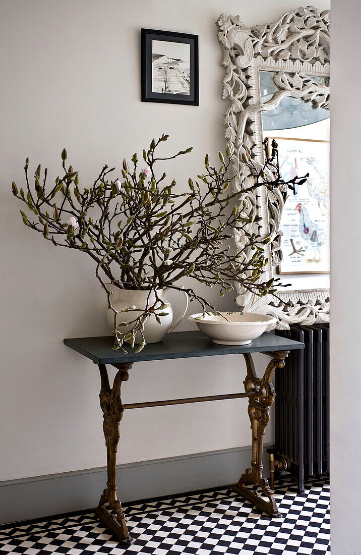 Monochrome hallway with display of blossom on a console table