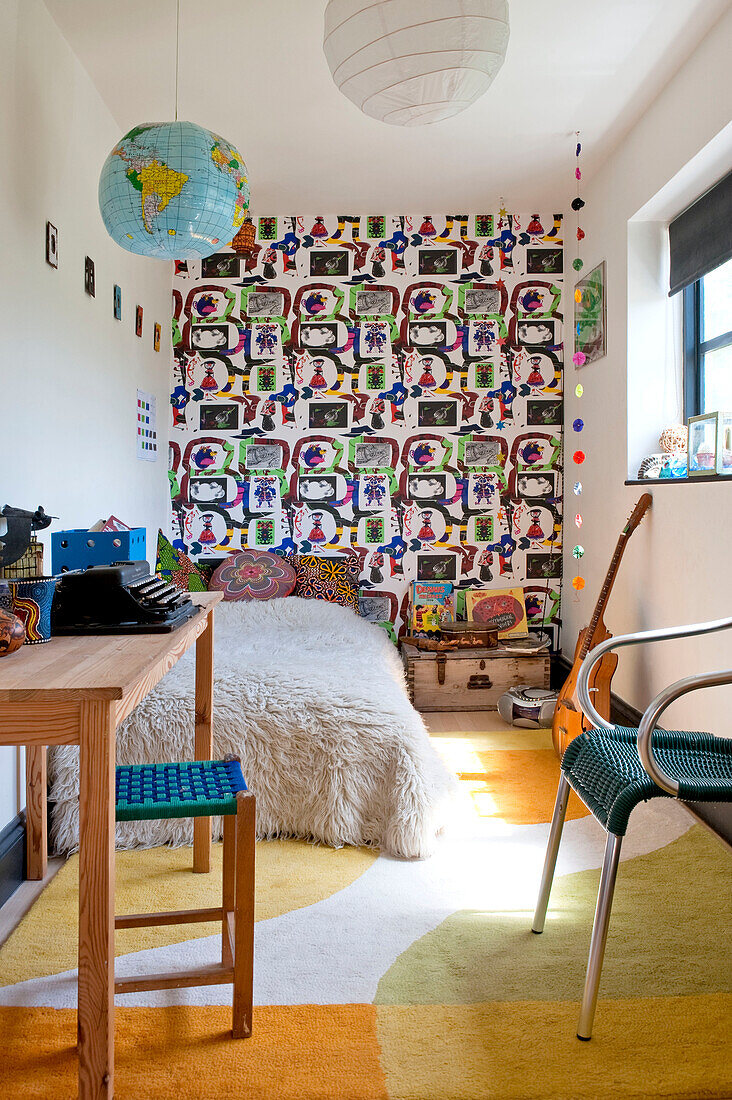 Typewriter on desk with patterned wallpaper in teenager's room of UK home