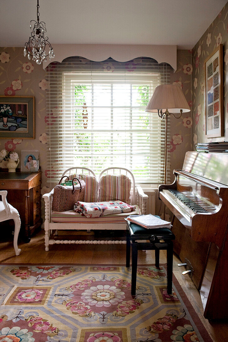 Zweisitziges Sofa am Fenster eines Londoner Hauses mit Klavier und Lampe England UK