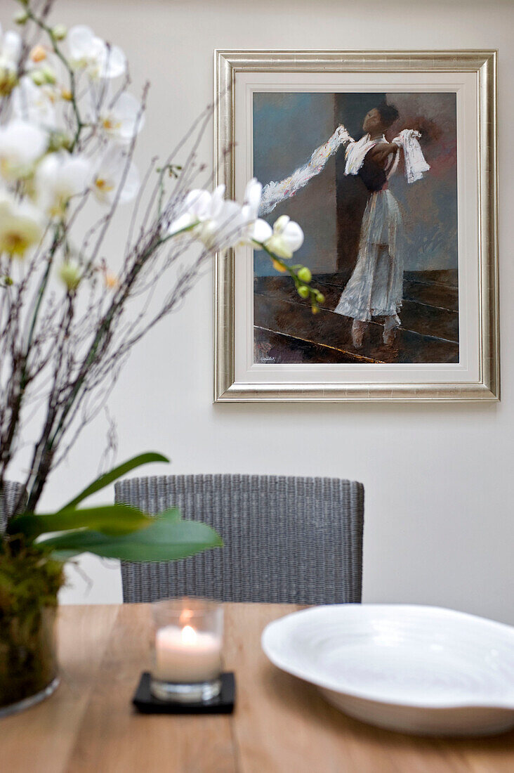Orchideen und Haushaltswaren auf einem Esstisch mit dem Kunstwerk einer Tänzerin in einem Stadthaus in West London, England UK