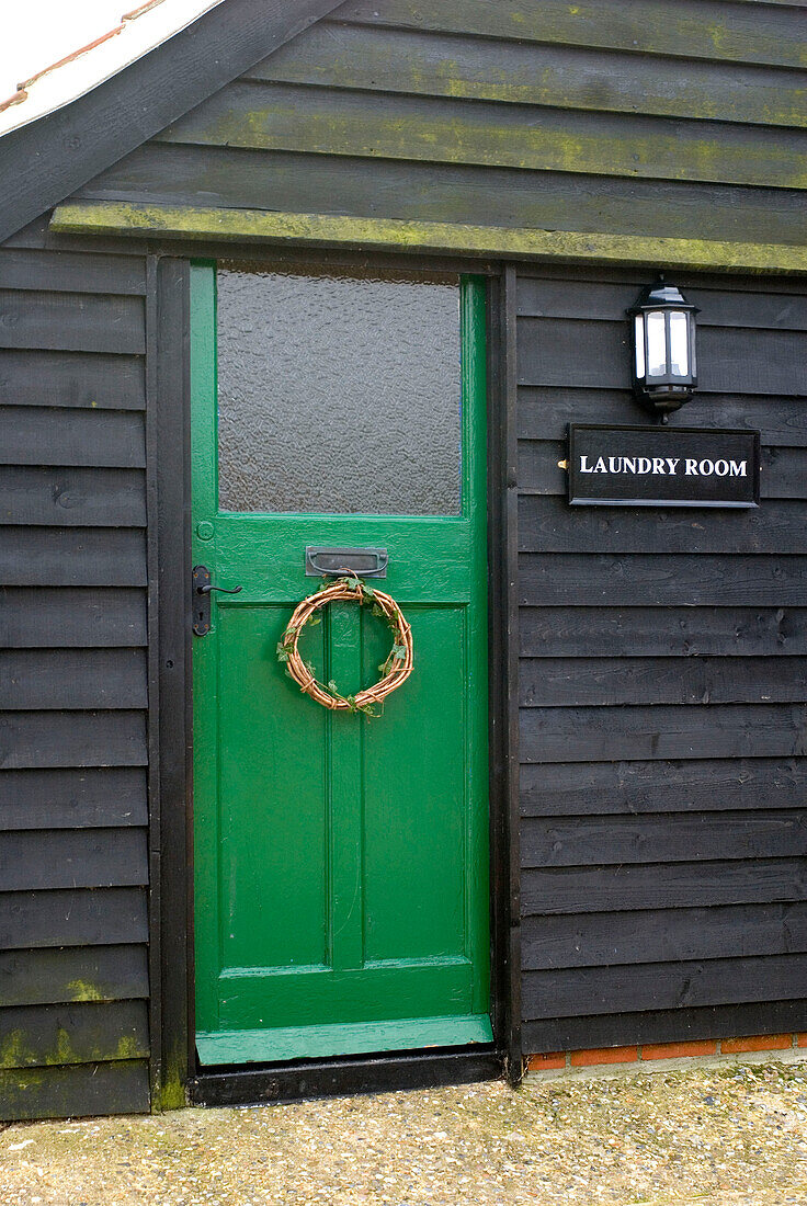 Hellgrüne Tür zur Waschküche in einem Haus im ländlichen Suffolk, England UK