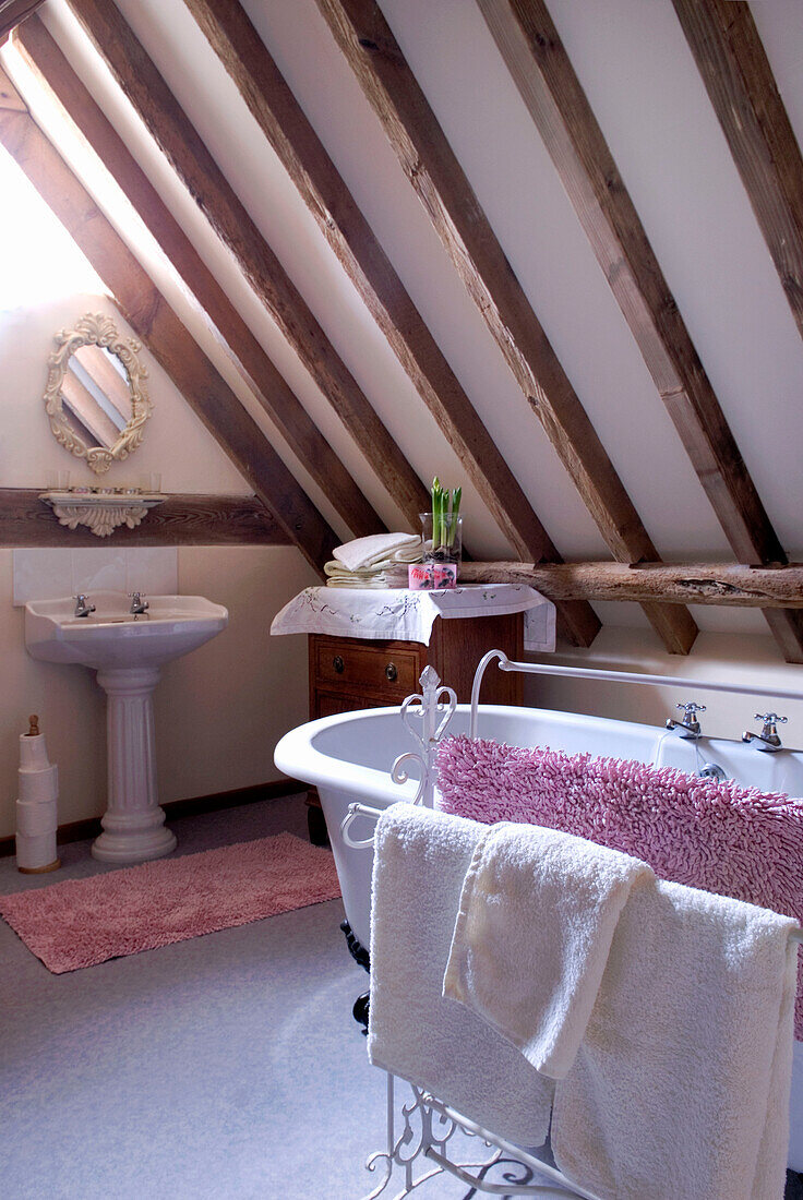 Freistehende Badewanne und Handtuchhalter im umgebauten Dachgeschoss eines Hauses in Suffolk, England UK