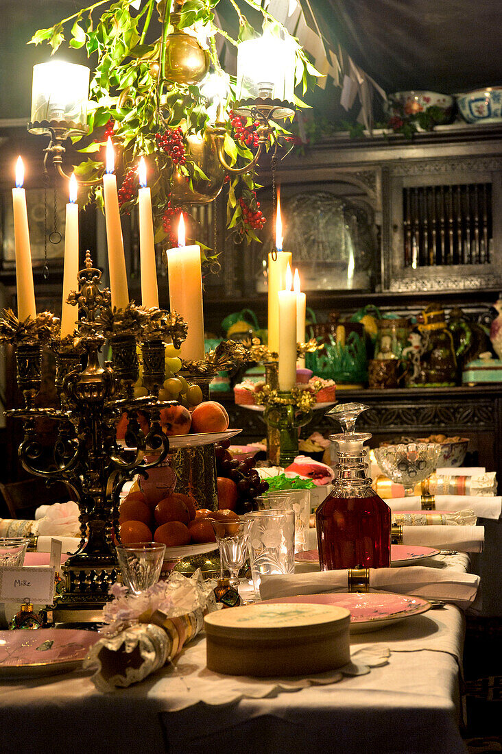 Lit candles on dining room table set for Christmas dinner in Cheltenham country home Gloucestershire England UK