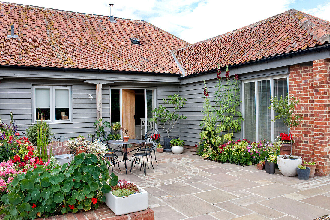 Gartenmöbel auf der Terrasse eines Hauses mit Klappe in Suffolk, England UK