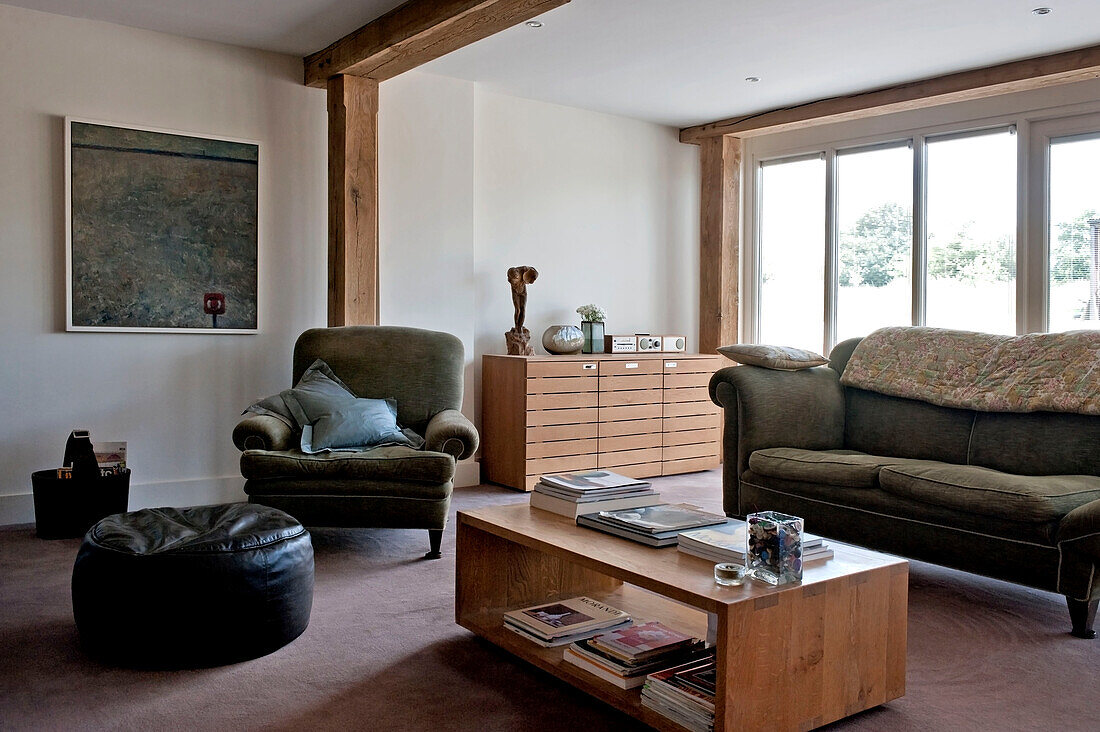 Dreiteilige Sitzgarnitur und Kunstwerk im modernen Wohnzimmer mit Balken in einem Haus in Suffolk, England, Vereinigtes Königreich