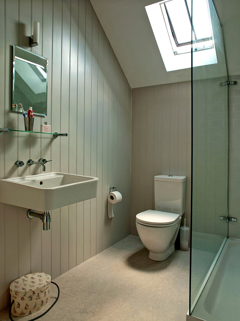 Getäfeltes Badezimmer mit Oberlicht und wandmontiertem Waschbecken in einem Einfamilienhaus in Suffolk, England, UK