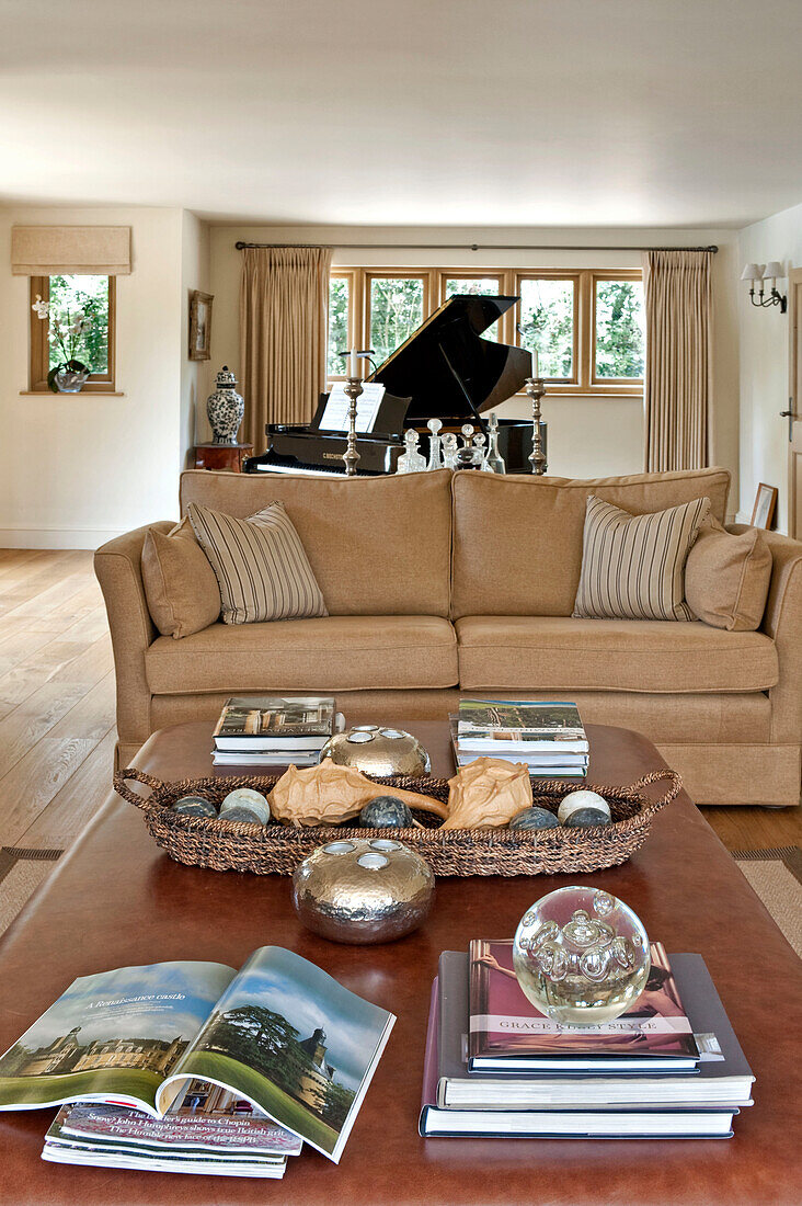 Flügel und zweisitziges Sofa mit Couchtisch und Büchern in einem Haus in Canterbury, England UK