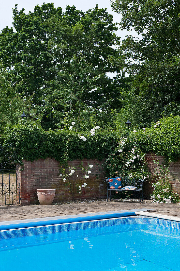 Sitzbank an der Ecke eines ummauerten Swimmingpools in Canterbury, England UK