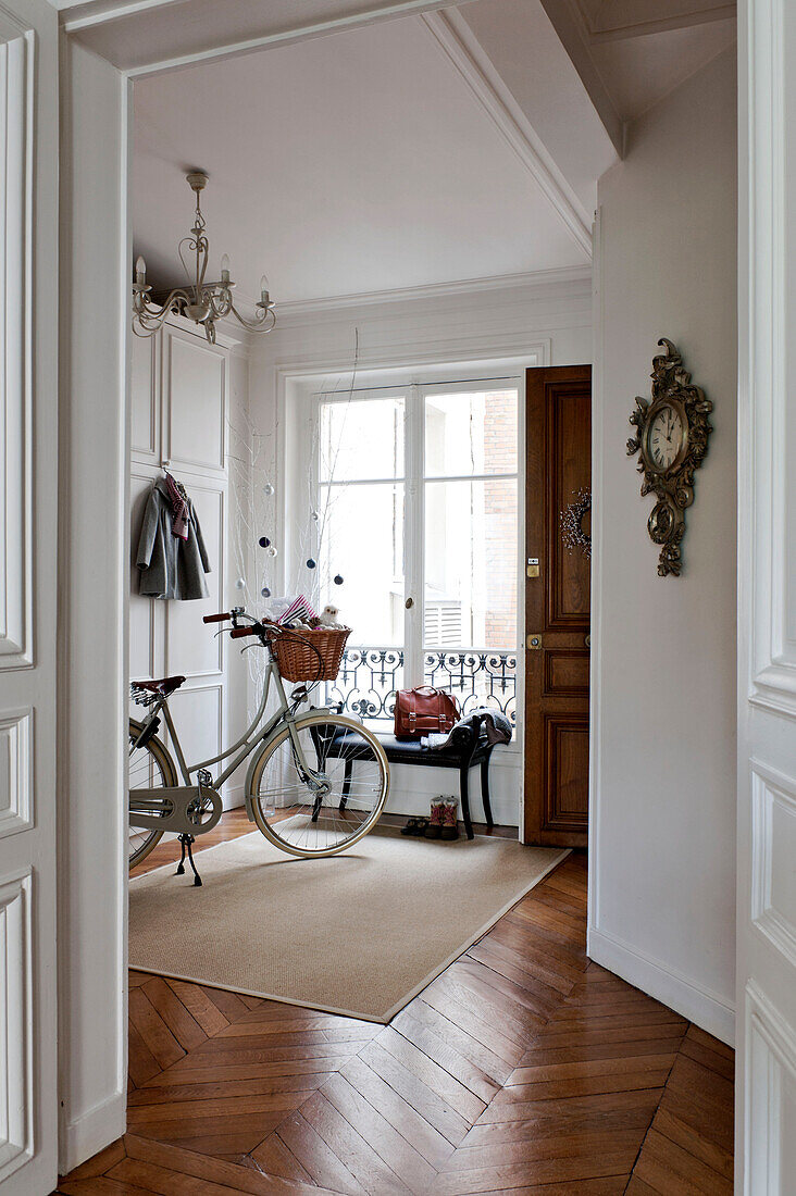 Fahrrad in einem weißen Flur mit Parkettboden in einer Pariser Wohnung, Frankreich