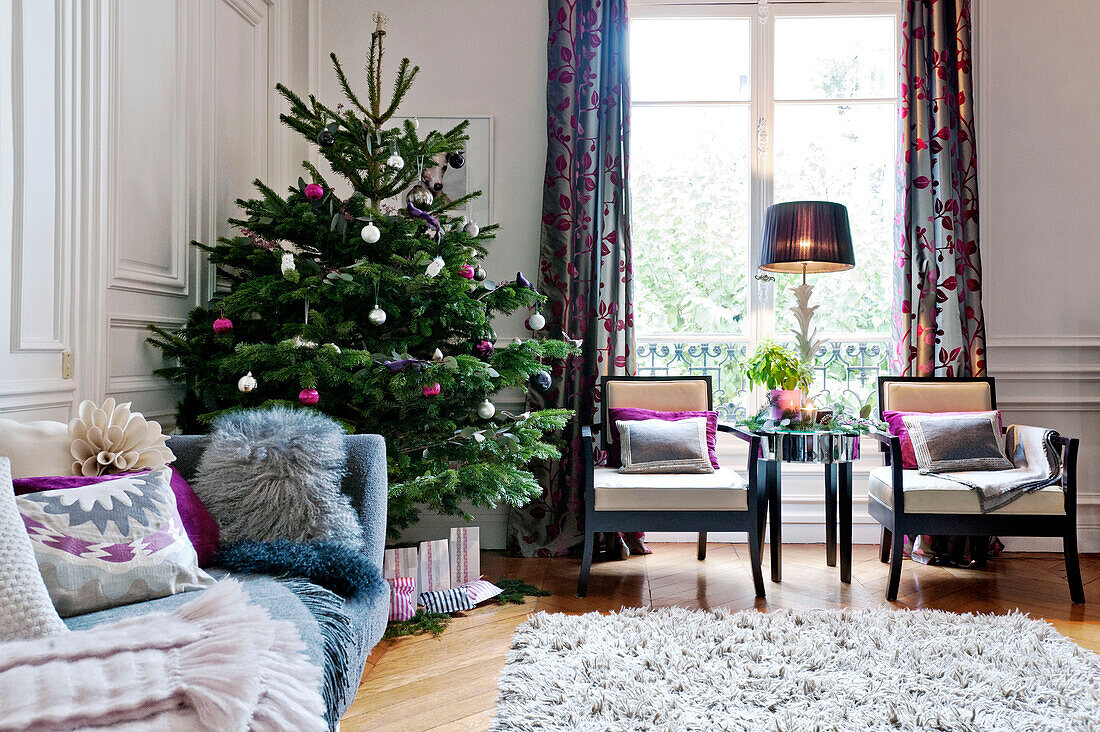 Weihnachtsbaum in einer Ecke des Wohnzimmers in einer Wohnung in Paris, Frankreich