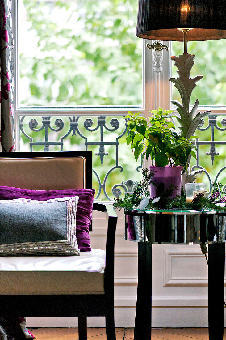 Sessel und verspiegelter Beistelltisch vor französischen Türen in Pariser Wohnung, Frankreich