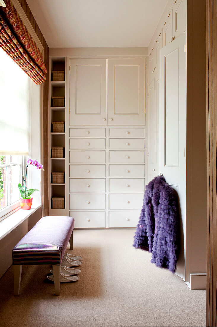 Lila Mantel mit eingebautem Schrank im Ankleidezimmer eines Hauses im ländlichen Suffolk, England, UK