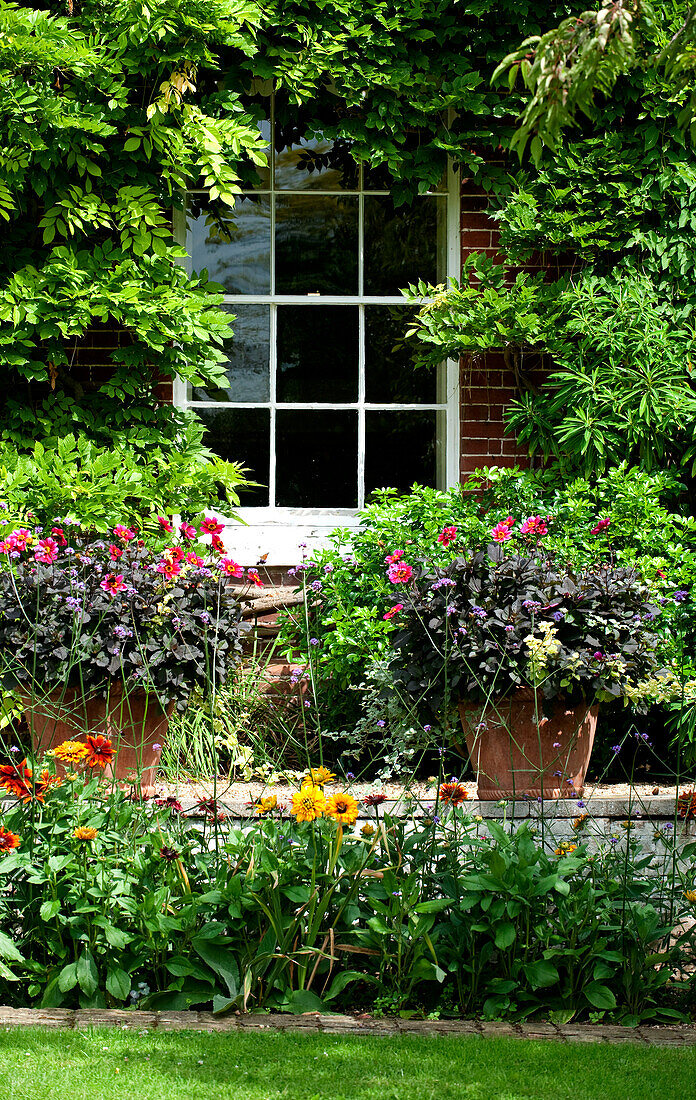 Window and garden exterior of rural brick Suffolk country house England UK
