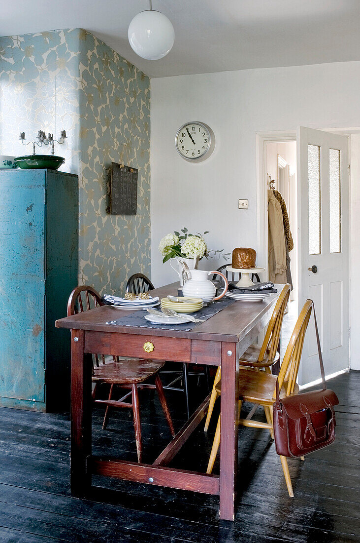 Schulranzen auf der Stuhllehne am Küchentisch in einem modernen Haus in London, UK
