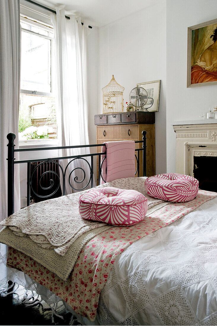 Rosa und weiße Kissen mit Steppdecken im sonnigen Schlafzimmer eines Landhauses in London, UK