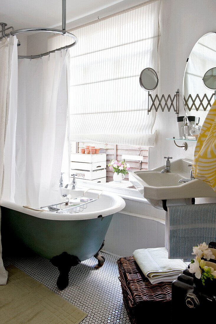 Badezimmer mit altmodischer Duschstange über freistehender Badewanne in einem Londoner Haus, UK