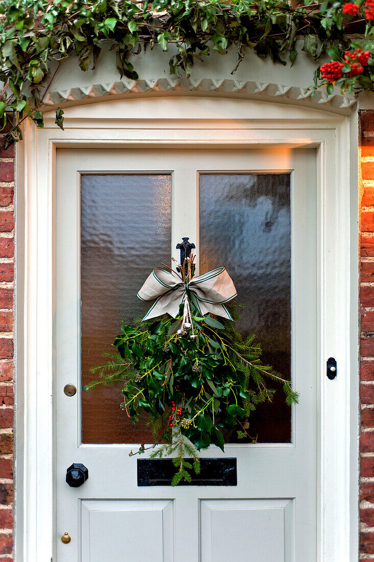 Christmas wreath on glass paned front door of Walberton home, West Sussex, England, UK