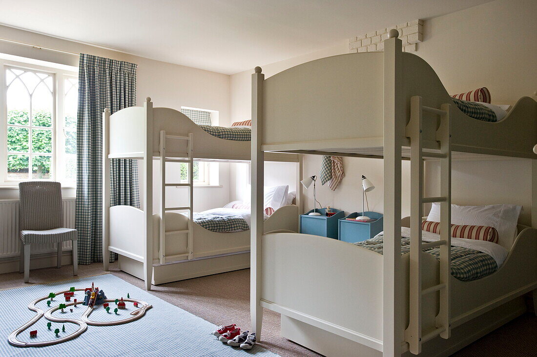 Kinderzimmer mit zwei Etagenbetten und Autorennbahn auf dem Boden in einem Haus in Buckinghamshire, England, UK
