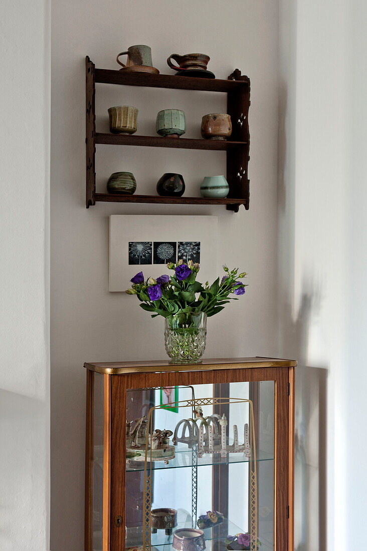 Vintage dresser and wall mounted shelf with ceramics in Bovey Tracey family home, Devon, England, UK