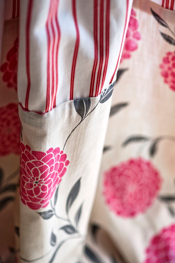 Pink floral patterned and striped fabric in Bovey Tracey family home, Devon, England, UK