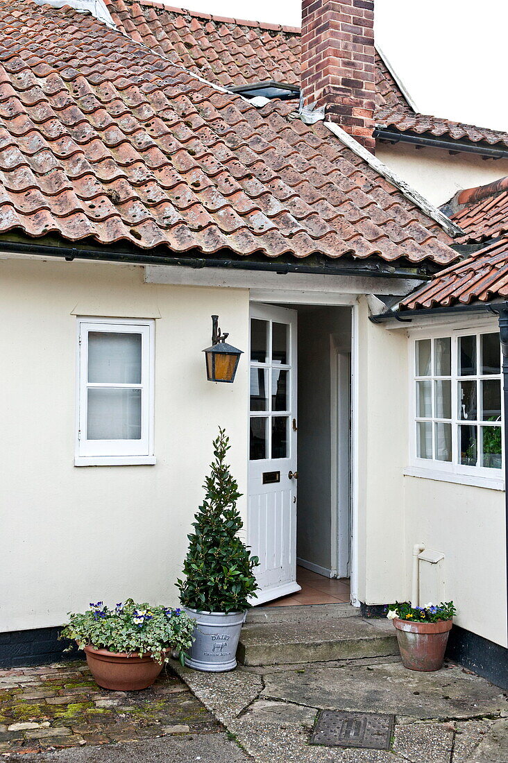 Offene Eingangstür zu einem gefliesten Cottage in Suffolk, England, UK