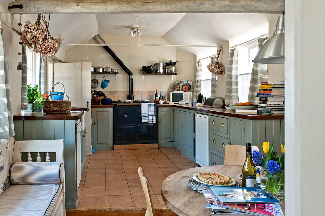 Marineblauer Herd in einer Küche auf zwei Ebenen in einem Bauernhaus in Suffolk, England, Vereinigtes Königreich
